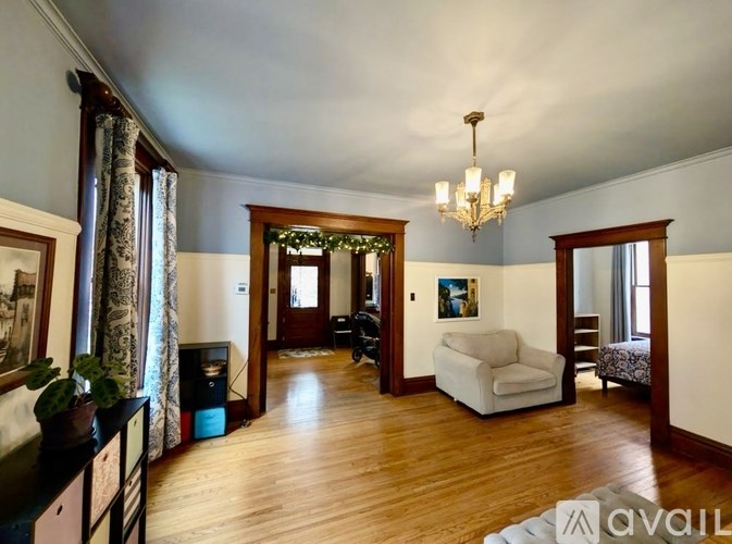 A living room with a white couch and a chandelier.