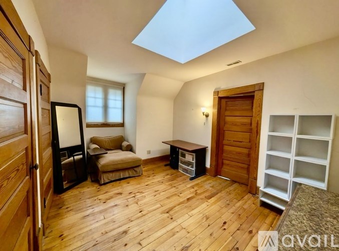 A room with wooden floors and a skylight.
