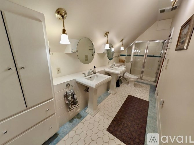A bathroom with a sink, mirror, toilet, and shower.