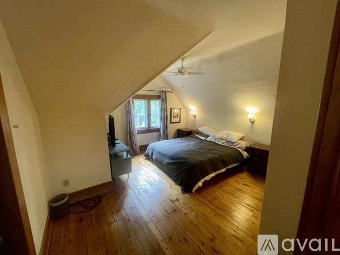 A bedroom with a bed, a dresser, and a window.