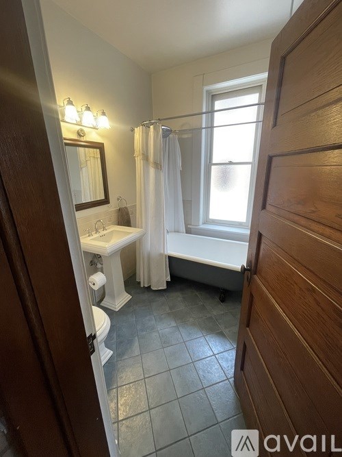 A bathroom with a toilet, sink, and bathtub.