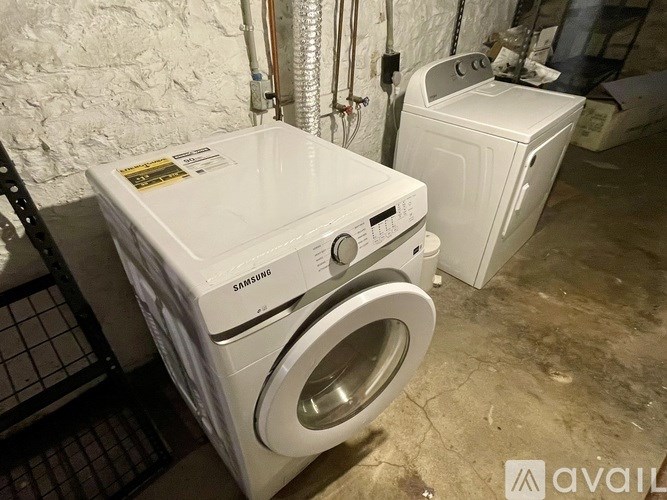 A white Samsung washing machine and dryer are in a basement.