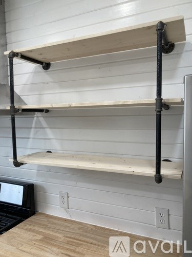 A white shelving unit with three shelves and black supports.