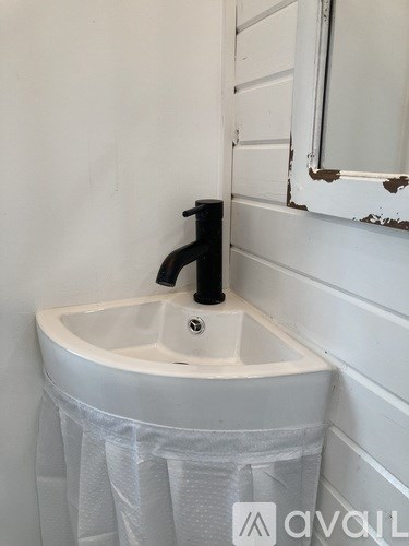 A white sink with a black faucet is in a bathroom.