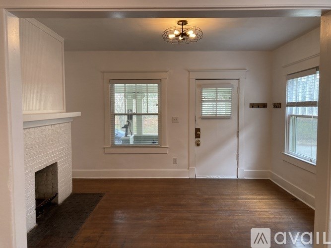 A room with a fireplace and wooden floors.