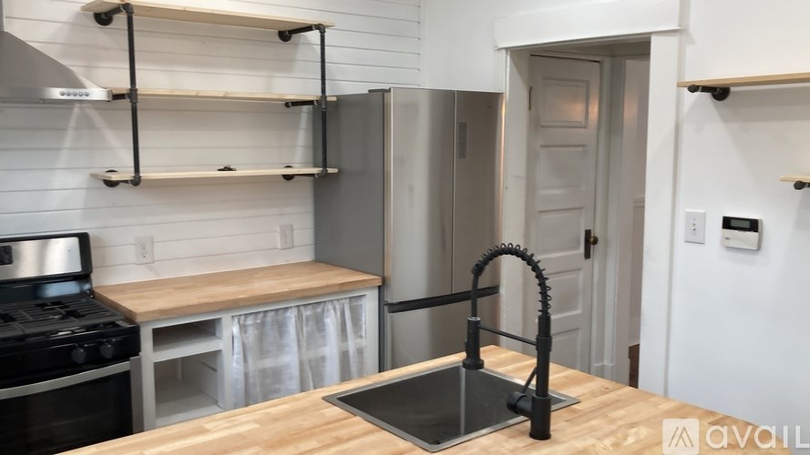 A kitchen with a stove top oven, a sink, and a refrigerator.