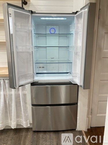 A stainless steel refrigerator with its door open.