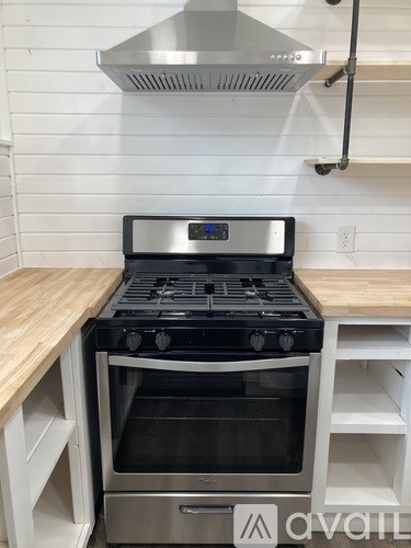 A modern kitchen with a stainless steel range hood above a stove.
