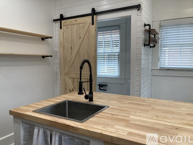 A kitchen with a wooden countertop and a black sink.