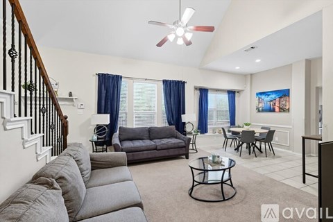 A living room with a grey couch and a black coffee table.