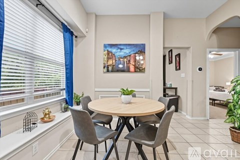 A dining room with a round table and chairs.