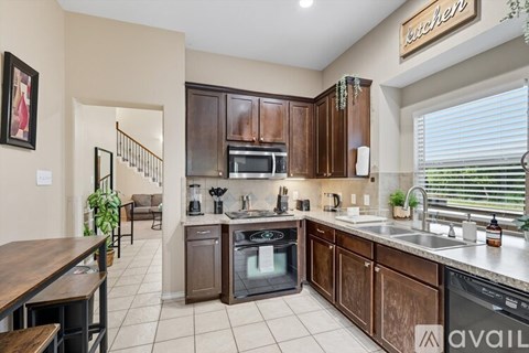 A kitchen with brown cabinets and a stainless steel dishwasher.