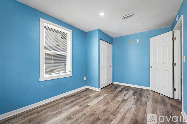 A kitchen with blue walls and wooden floors.