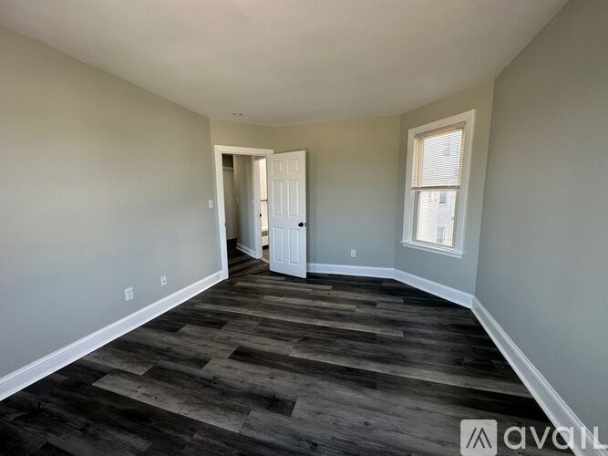 A room with wooden flooring and a white door.