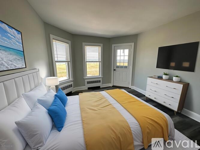 A bedroom with a bed, dresser, and window.