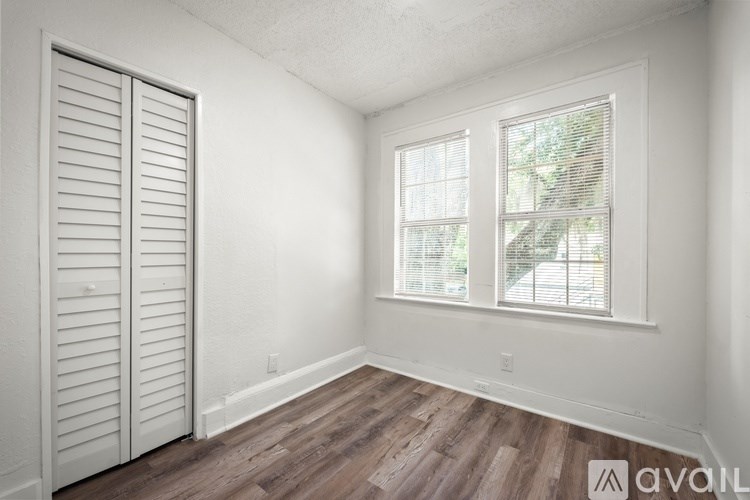 A room with a sliding door and a window with blinds.