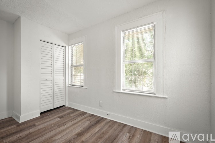 A room with a window and a door with blinds.