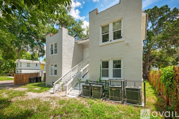 A white house with a staircase leading to the front door.