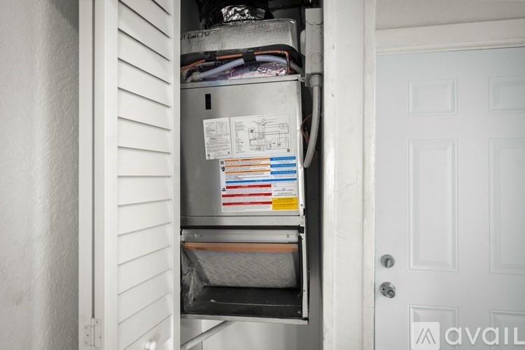 A white door is open to a small, cluttered kitchen pantry.