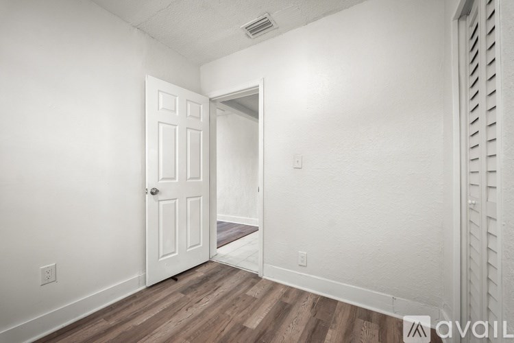 A room with a white door and a window with blinds.