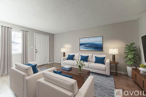 A living room with a white sofa set and a painting on the wall.