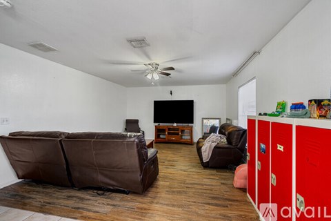 A living room with a brown couch and a television.