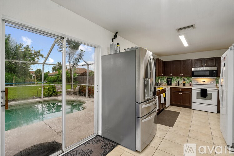 A kitchen with a refrigerator, oven, and sink.