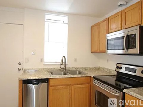 A kitchen with wooden cabinets and a black stove top oven.