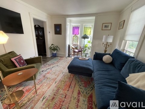 A living room with a blue couch and a green chair.