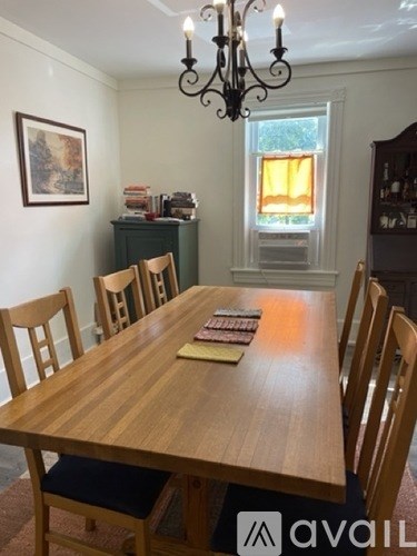 A dining room with a wooden table and chairs.