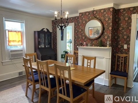 A dining room with a wooden table and chairs.