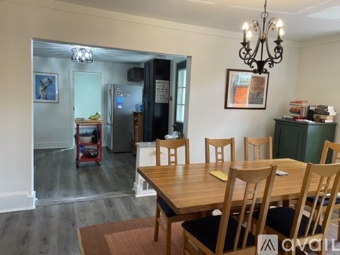 A dining room with a wooden table and chairs.