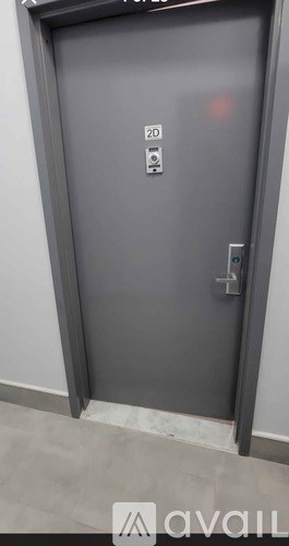 A grey door with a handle and a keypad on the right side.