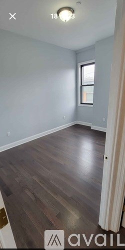 A room with wooden flooring and a window.