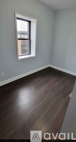 A room with a window and wooden flooring.
