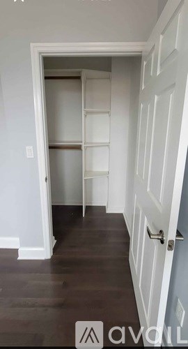 A hallway with a white door and a wooden floor.