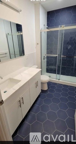 A bathroom with a blue hexagonal tile floor.