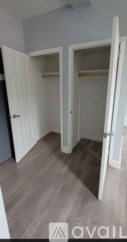 A room with a white door and a wooden floor.