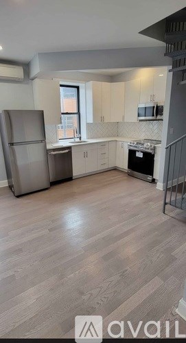 A kitchen with a refrigerator, microwave, oven, and stove.