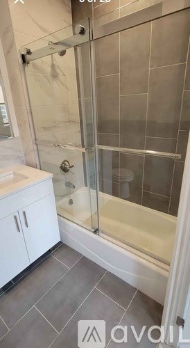 A modern bathroom with a glass shower enclosure and white cabinetry.