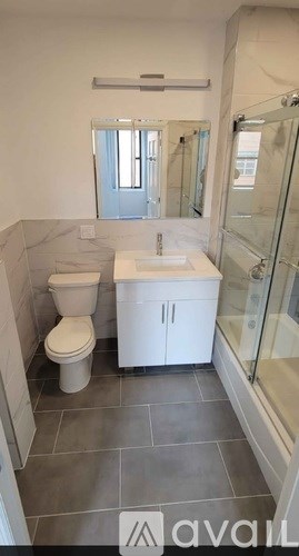 A bathroom with a toilet, sink, and shower.