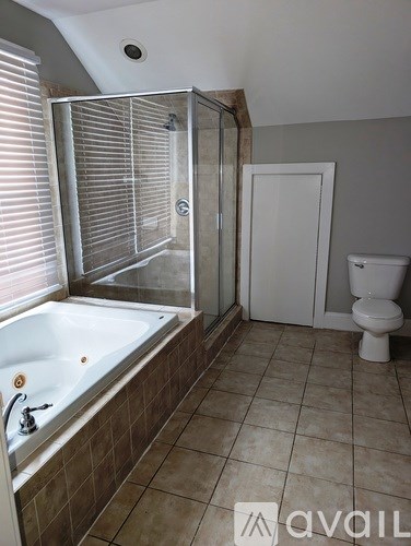 A bathroom with a tub, toilet and shower.
