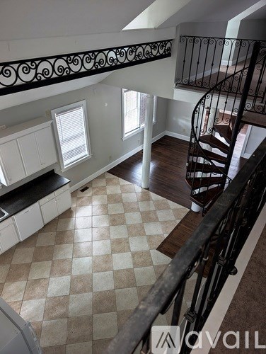 A large open space with a checkered floor and a spiral staircase.