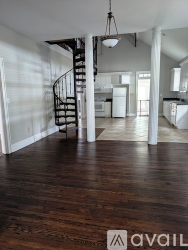 A large open space with a spiral staircase leading to the upper floor.