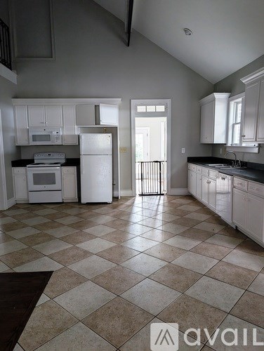 A kitchen with white appliances and cabinets.