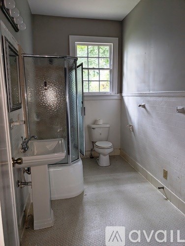 A bathroom with a toilet, sink, and shower.