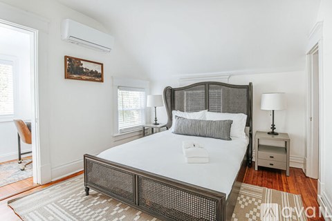 A bedroom with a large bed and a painting on the wall.