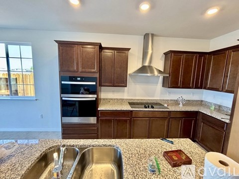 A kitchen with brown cabinets and a stainless steel sink.