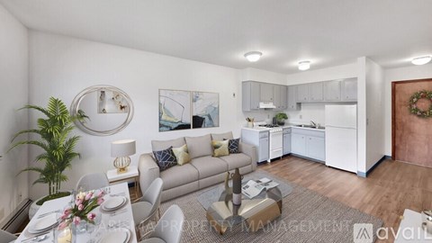 A well-lit, modern living room with a dining area and kitchen in the background.