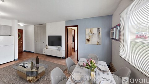A modern living room with a dining area and a kitchen in the background.